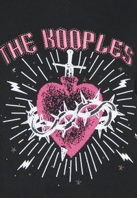 Czarna koszulka graficzna z różowym sercem, ozdobionym akcentami miecza i cierni, otoczonym białymi promieniami i metalicznymi detalami gwiazd.