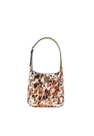 Cowhide bag with a rounded shape; spotted pattern in orange, black, and white. Features a black shoulder strap and attached hardware accent.