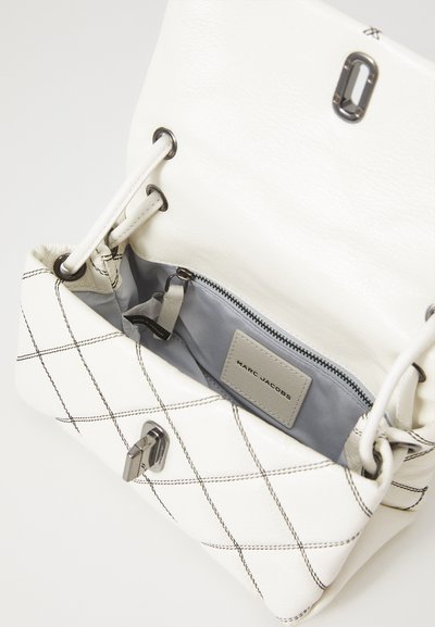 Bolsa de pele branca com padrão de matelassé em diamante, interior cinza, bolso com fecho zip e acessórios em prata. Apresenta um fecho magnético e alças ajustáveis.