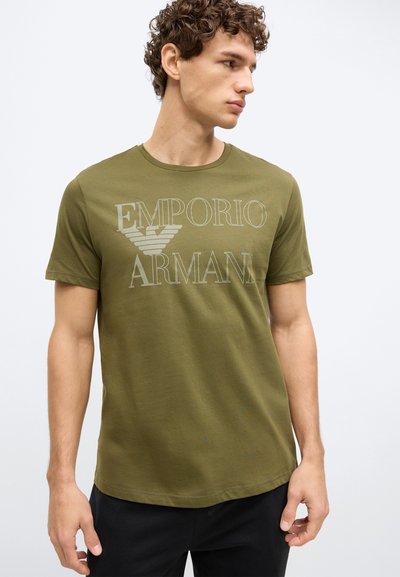 Olivzaļš kokvilnas T-krekls ar īsām piedurknēm un apaļu kaklu, priekšpusē ar lielu gaiši pelēku "Emporio Armani" logotipu.