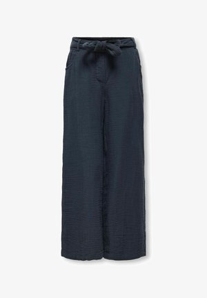 Tamsiai mėlynos platėjančios kelnės iš tekstūruotos medžiagos, su surišamu juosmens diržu ir šoninėmis kišenėmis. Ant medžiagos matyti švelnūs raukšlių pėdsakai.