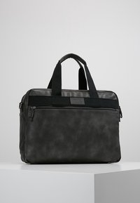 Schwarze Laptop-Tasche aus synthetischem Material mit zwei oberirdischen Griffen, vorderer Reißverschlusstasche und glatter Oberfläche. Kompakte rechteckige Form.