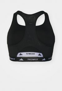 Črn športni nedrček z zasnovo z racerback, ki ima teksturiran material in širok elastični trak z belim logotipom na dnu.