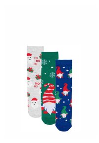 Tre paia di calzini: grigi con Babbo Natale e regali, verdi con fiocchi di neve e blu con gnomi su uno sfondo nevoso; materiale in cotone.