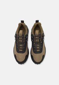 Buitenschoenen met een combinatie van bruine en zwarte materialen, een gestructureerde mesh bovenzijde, een robuuste zool en een verstevigde neus voor duurzaamheid.