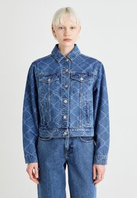 Modra jeans jakna s skrajšanim dizajnom, ki ima diamantni vzorec, prsni žepek, srebrne gumbe in klasičen ovratnik.