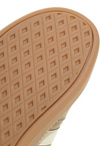 Semelle de chaussure avec semelle extérieure en caoutchouc beige présentant un motif de bande de roulement en relief en forme de losange pour une meilleure adhérence et traction.