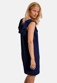 Abito senza maniche blu navy con dettagli arricciati sulle spalle, vestibilità ampia, lunghezza sopra il ginocchio, realizzato in tessuto leggero.