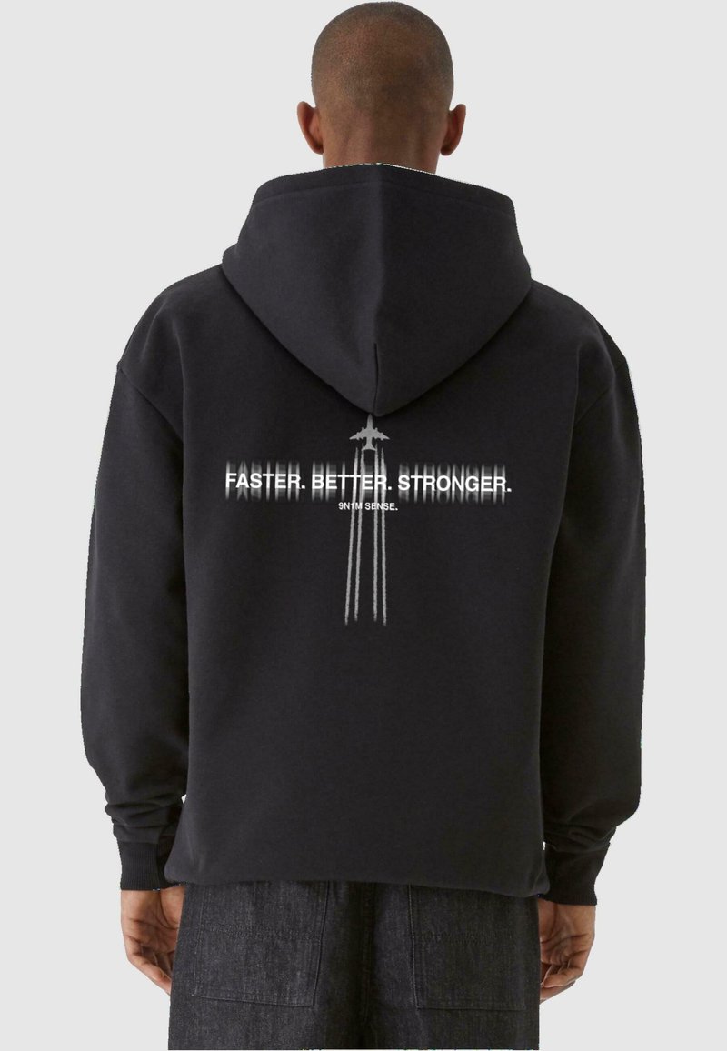 Felpa nera con cappuccio regolabile, con testo bianco che recita "PIÙ VELOCE. MIGLIORE. PIÙ FORTE." sul retro, con accenti di linee verticali.