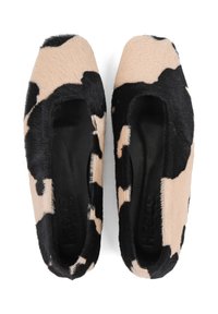 Płaskie buty w wzór krowi o miękkiej, puszystej teksturze. Przeważnie beżowe z czarnymi plamami. O zaokrąglonym nosku i wsuwanym fasonie. Czarna podszewka wewnętrzna.