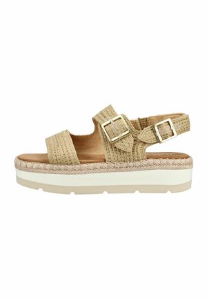 Beige geweven sandalen met plateauzool, voorzien van twee verstelbare gespen in goudkleur en een dikke witte zool met gevlochten detail erboven.