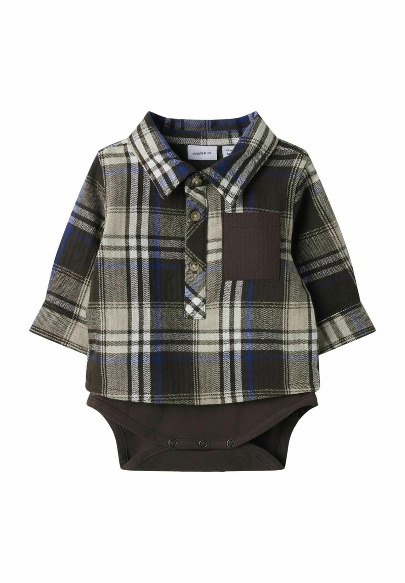 Camicia a maniche lunghe scozzese in verde, grigio e blu, con un body marrone sotto; presenta chiusura con bottoni e tasca frontale.