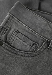 Siva jeansa tkanina z žepom na sprednji strani, z vidnim šivom in kovinskim gumbom. Tekstura je videti gladka in rahlo obrabljena.