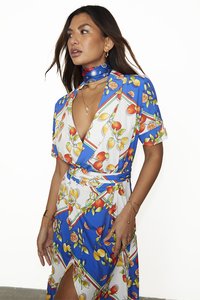 Rochie florală cu decolteu în V adânc, mâneci scurte, fond albastru, modele de portocale și lămâi, și o deschidere laterală pentru un detaliu suplimentar.