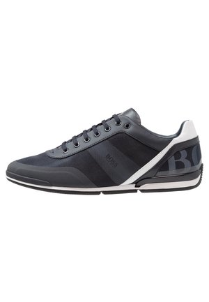 Sort-hvid lavtop sneaker med snørebånd, mesh og læder overdel samt polstret krave til fritidsbrug.
