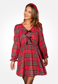 Rood geruite jurk met lange mouwen, V-hals en zwarte lintaccenten. Heeft een getailleerde taille en een losse, wijd uitlopende rok. Soepele stofstructuur.