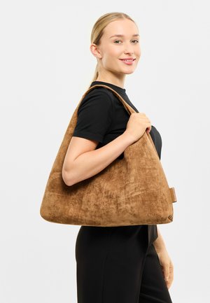 Braune Wildleder-Handtasche mit dreieckiger Form, breitem Schulterriemen, weicher Textur und kleinem Markenetikett.