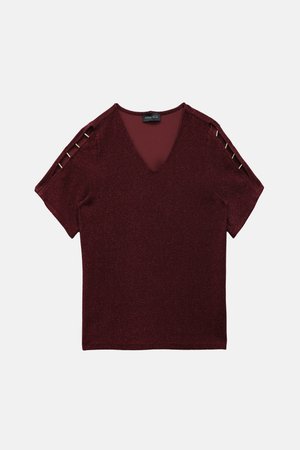 Burgundy short-sleeve top with a V-neck, textured sparkly fabric, featuring decorative gold-colored accents on the shoulder.