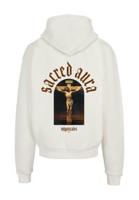 Weißer Kapuzenpullover mit einem zentralen Grafikmotiv einer Kreuzigungsszene, darüber der Text "sacred aura" in stilisierter brauner Schrift und darunter "migonzaels".