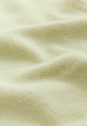 Puha, világos sárga szövet finom textúrával és lágy redőkkel, amelyek finom árnyékokat és fényeket hoznak létre.