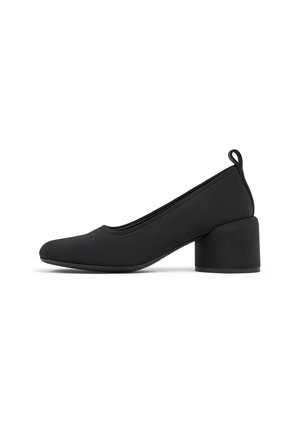 Scarpa da donna nera con tacco basso a blocco, punta arrotondata e linguetta al tallone, mostrata di profilo su sfondo bianco.