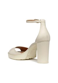 Vita högklackade sandal med ankelrem, öppen tå-design, slät konstläder, vadderad sula och en texturerad plattform för stabilitet.