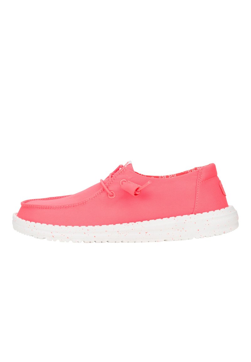 Scarpa slip-on di un vivace colore rosa, con tomaia in sintetico liscio, suola bianca maculata e semplici dettagli in pizzo. Design piatto e texture leggera.
