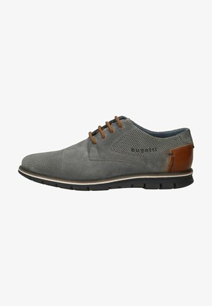 Scarpa in suede grigia con design forato, dettagli in pelle marrone e suola in gomma nera. Presenta lacci e un interno blu a contrasto.