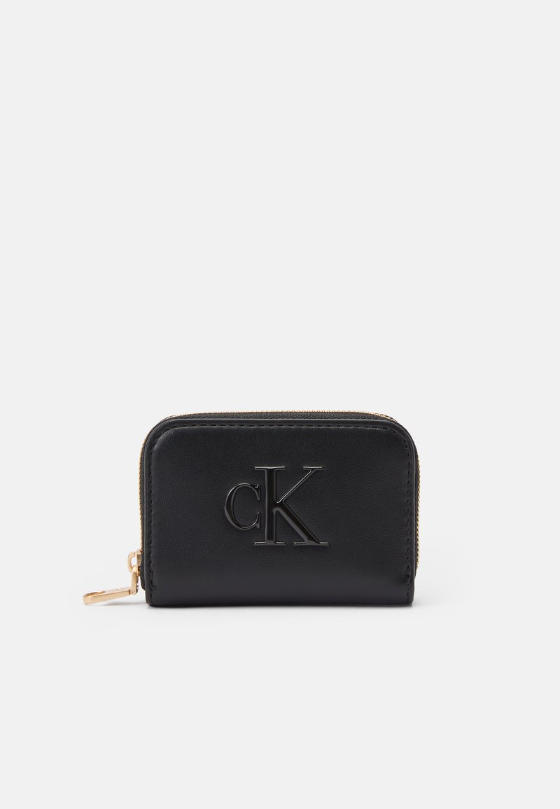 Black leather wallet with raised "cK" logo, gold zipper accent, rectangular shape, smooth texture, compact design.