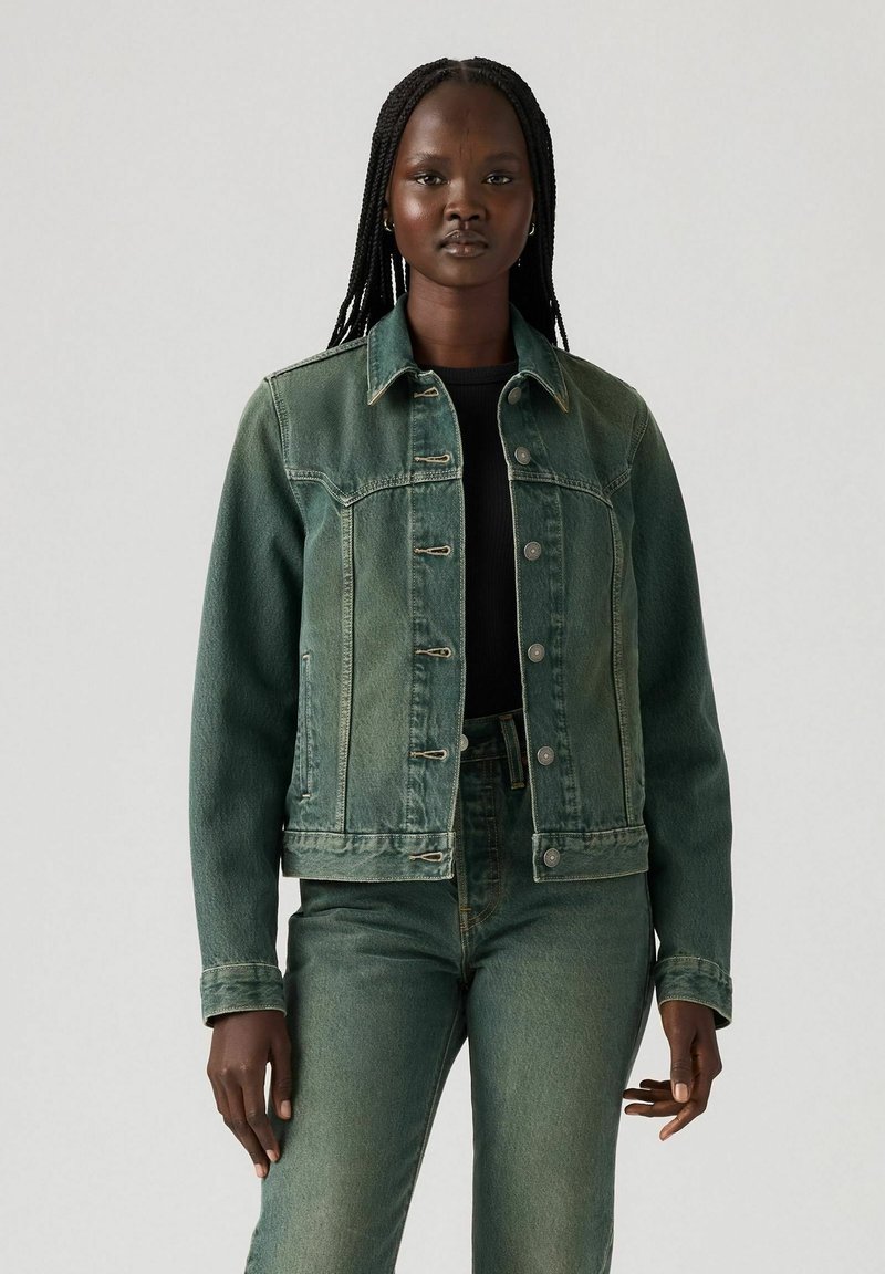 Green denim jacket with a button-up front, two chest pockets, and a slightly faded texture. Paired with matching green denim pants.