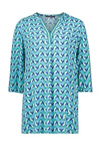 Turquoise tuniek met V-hals, driekwartmouwen en een geometrisch patroon in verschillende tinten blauw en groen. Soepele stoftextuur.