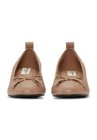 Para beżowych pikowanych balerin z małymi kokardkami na przodzie i pętelkami na piętach, widocznych z przodu na białym tle.