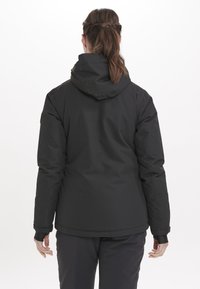 Schwarze, wasserdichte Jacke mit Kapuze, komprimiertem Material und verstellbaren Manschetten. Besitzt eine glatte Textur ohne sichtbare Beschläge.