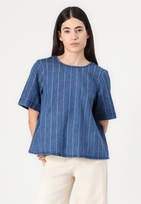 Top in denim a righe blu con maniche corte, scollatura rotonda e vestibilità comoda. Presenta cuciture visibili e orlo grezzo.