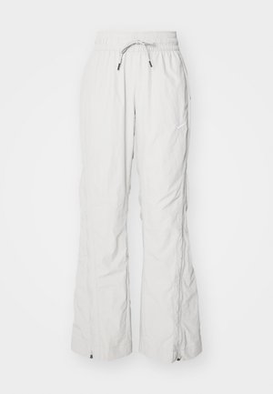 Calças cargo cinza claro feitas de tecido texturizado, apresentando uma cintura elástica com cordão, bolsos laterais e fechos de correr nos tornozelos.