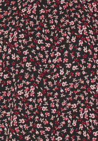 Tessuto nero con una piccola stampa floreale nei toni del rosa e del rosso. Il motivo presenta fiori sparsi su uno sfondo testurizzato.