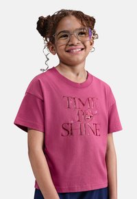 Camiseta de algodón rosa con mangas cortas, que presenta "HORA DE BRILLAR" en letras metálicas texturizadas. Acabado suave, corte relajado.