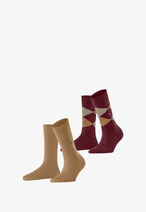 Deux paires de chaussettes : l'une en beige uni, l'autre bourgogne avec un motif en losanges crème et rouge. Les deux sont de hauteur cheville et comportent un détail de logo.