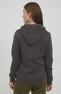 Šedá mikina s kapucňou vyrobená z texturovanej látky, ktorá má klokaní vrecko, rebrované manžety a malú logo nášivku na leme.