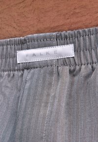 Tissu à motif chevrons gris et blanc doté d'une ceinture élastique. L'étiquette affiche "FALKE" en lettres en relief.