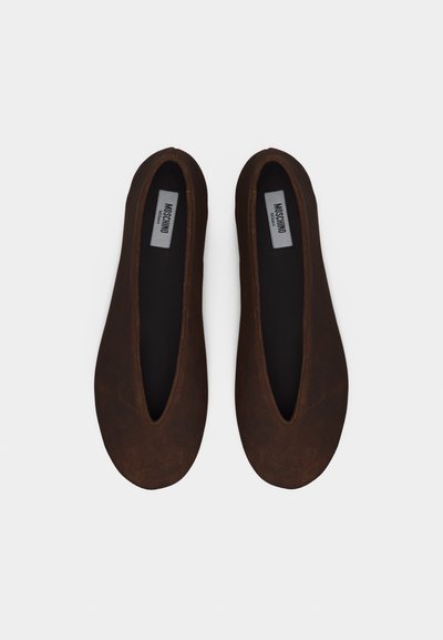 Paire de chaussures plates Moschino brun foncé avec bouts arrondis et semelles intérieures noires sur fond blanc.