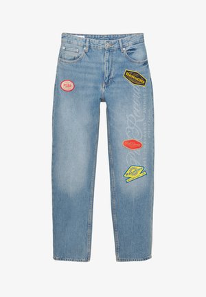 Lichtblauwe denim jeans met een losse pasvorm, voorzien van diverse kleurrijke patches en logo's. Verweerde textuur met zichtbare vervaging.