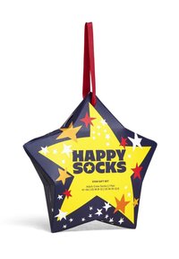 Caja de regalo en forma de estrella de color azul marino, adornada con estrellas amarillas, rojas y blancas. Etiqueta "HAPPY SOCKS" mostrada de forma prominente. Cinta roja colgante adjunta.