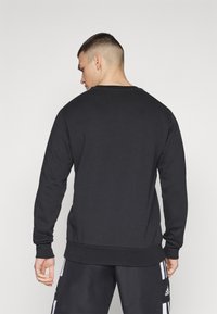 Sort sweatshirt med lange �ærmer, rund hals, ribbet kant og manchetter. Den er lavet af et glat bomuldsblandingsmateriale og har et minimalistisk design.