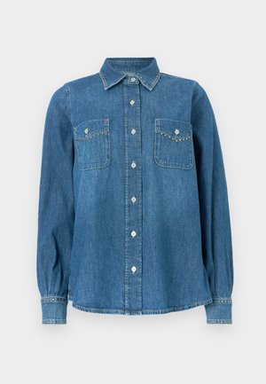 Denimskjorte med knappkrage, to brystlommer og dekorative nagler langs lommekantene og mansjettene. Blått stoff med myk tekstur.