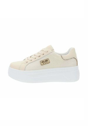 Zapatilla deportiva baja de color beige con tejido texturizado, cierre de cordones, suela gruesa blanca y una pequeña placa con el logotipo "4US" en el lateral.