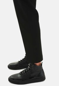 Mustad musta värvi kõrgemad tenniseketsid, mis on valmistatud siledast nahast läikivate detailidega, lace-up eesosa ja pehmendustega ankle support.