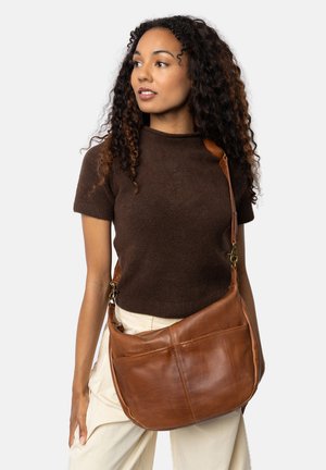 Bruine leren schoudertas met een slouchy vorm, voorzien van een brede schouderband, twee voorkwakken en een gladde textuur.