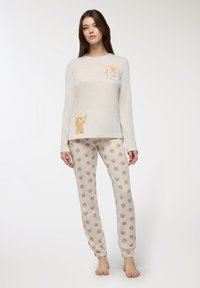 Set di pigiama grigio chiaro composto da una maglietta a maniche lunghe con una grafica di un orso e la parola "Amore", abbinata a pantaloni con un motivo che mostra volti di orso.