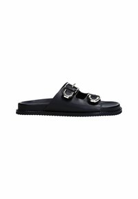 Sandale à glissière en cuir noir avec deux accents de boucle métallique, design à bout ouvert et semelle texturée pour une meilleure adhérence. Profil minimaliste et plat.